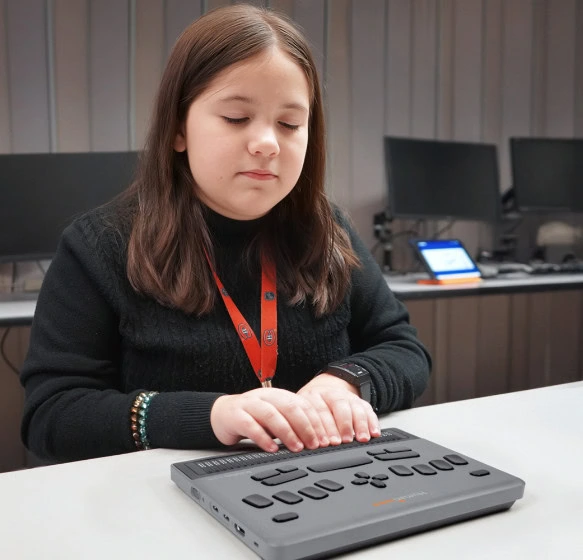 A student utilizing the BrailleNote evolve in a classroom setting.