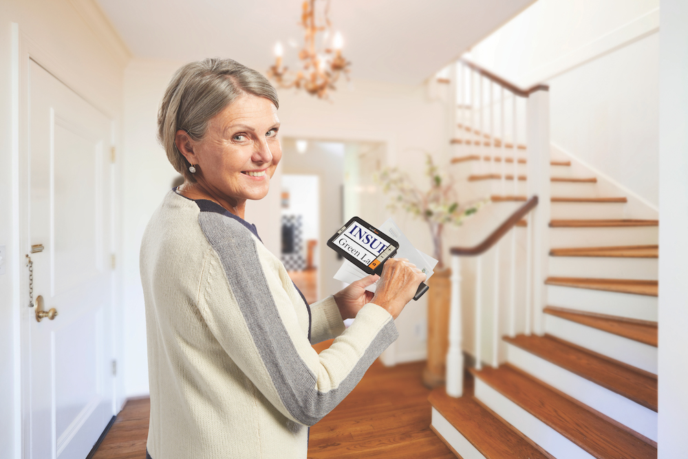 A woman using the Explore 5 HandHeld magnifier to look at mail.